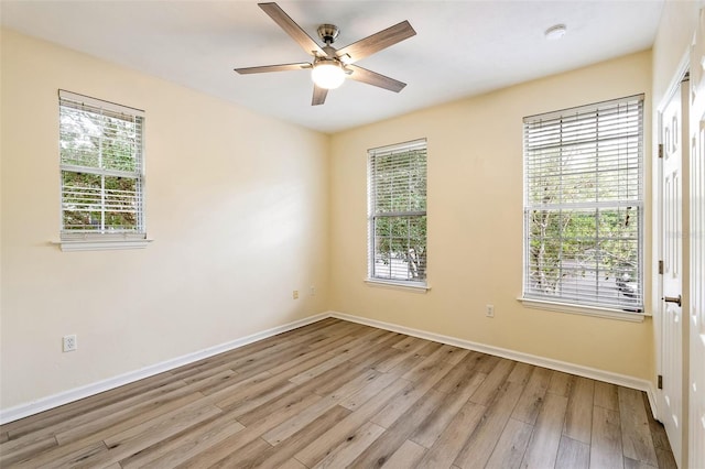 unfurnished room with baseboards, ceiling fan, a wealth of natural light, and wood finished floors