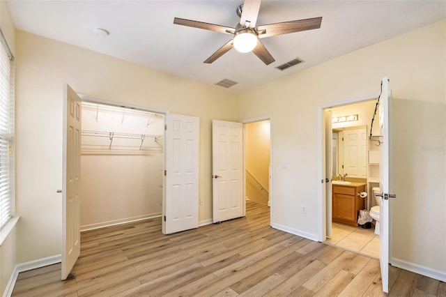 unfurnished bedroom with a closet, baseboards, visible vents, and light wood-style floors