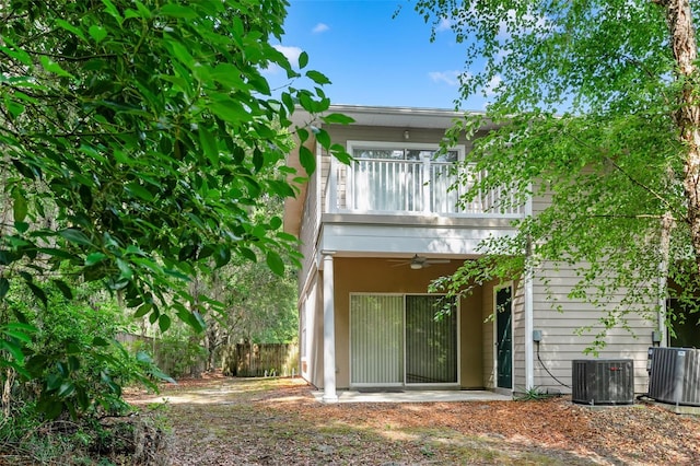 back of property featuring fence, cooling unit, a ceiling fan, and a balcony