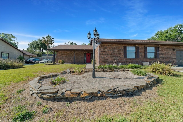 view of front of house featuring brick siding and a front lawn