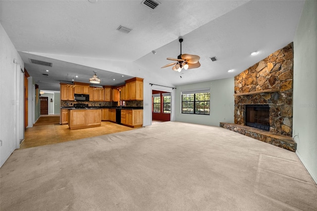 unfurnished living room with visible vents, ceiling fan, vaulted ceiling, and light carpet