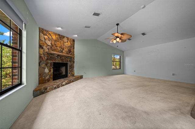 unfurnished living room with ceiling fan, visible vents, a fireplace, carpet floors, and lofted ceiling