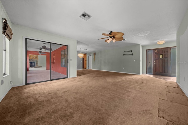 unfurnished living room with visible vents, carpet flooring, baseboards, and ceiling fan