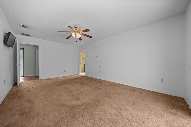 unfurnished room with baseboards, a ceiling fan, carpet flooring, and visible vents