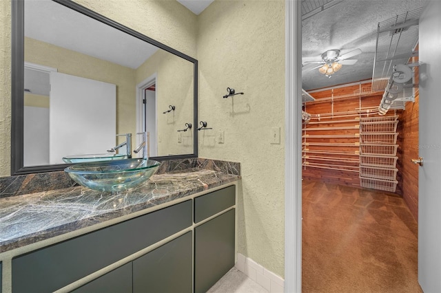 bathroom with vanity and a textured wall