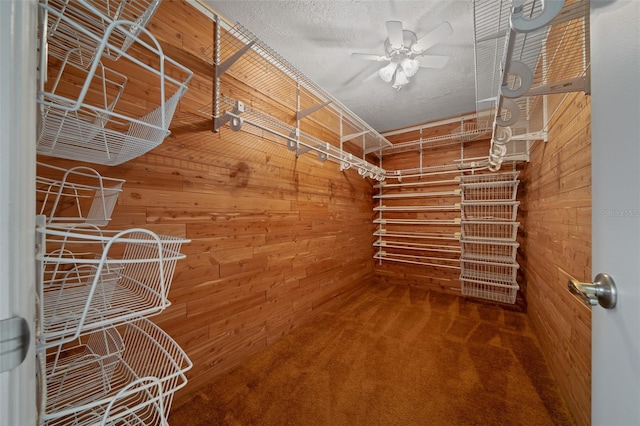 walk in closet with carpet and a ceiling fan
