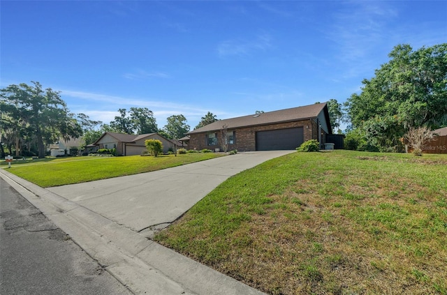 ranch-style home with a garage, driveway, brick siding, and a front yard