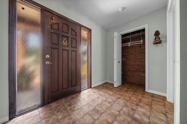 foyer entrance featuring baseboards and light tile patterned floors