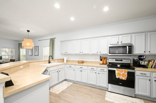 1488 NW 120th Way, Gainesville, FL 32606 - kitchen featuring crown molding, appliances with stainless steel finishes, a sink, light countertops, and a peninsula