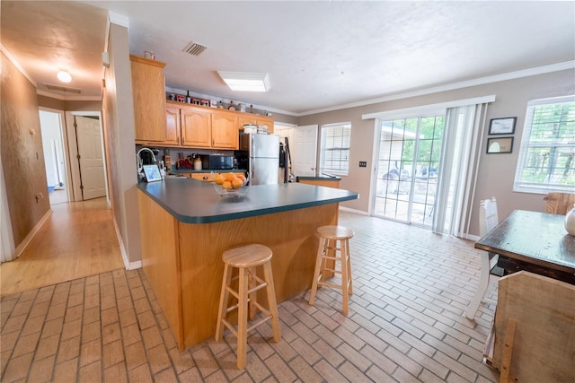 5876 SW 52nd Ter, Lake Butler, FL 32054 - kitchen featuring freestanding refrigerator, a peninsula, baseboards, a breakfast bar area, and brick floor