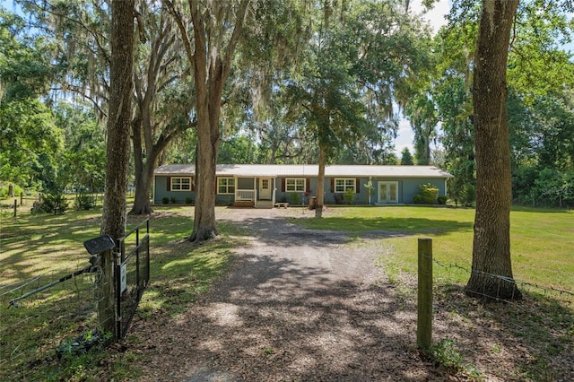ranch-style home featuring fence, driveway, and a front yard