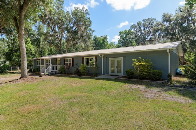ranch-style home with a porch, french doors, metal roof, and a front lawn