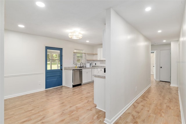 hallway featuring recessed lighting, a sink, baseboards, and light wood-type flooring