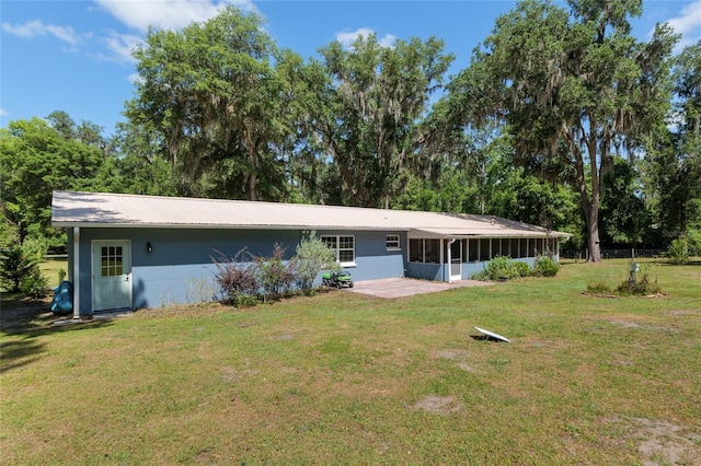rear view of house with a yard and a sunroom