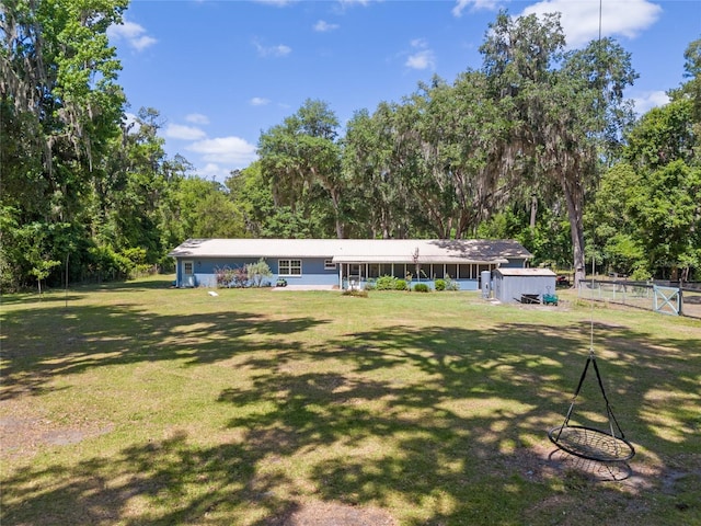 exterior space featuring an outdoor structure, fence, a yard, and a shed