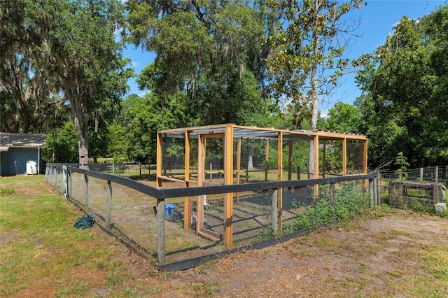 view of play area with fence, exterior structure, an outdoor structure, and a lawn
