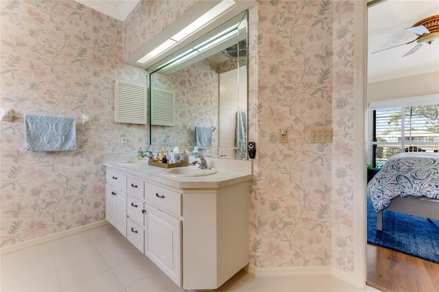 bathroom featuring a sink, baseboards, double vanity, and connected bathroom