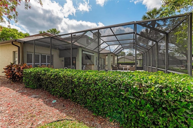 rear view of property featuring a lanai and stucco siding