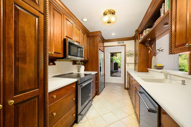 kitchen featuring tasteful backsplash, light countertops, light tile patterned floors, a sink, and stainless steel appliances