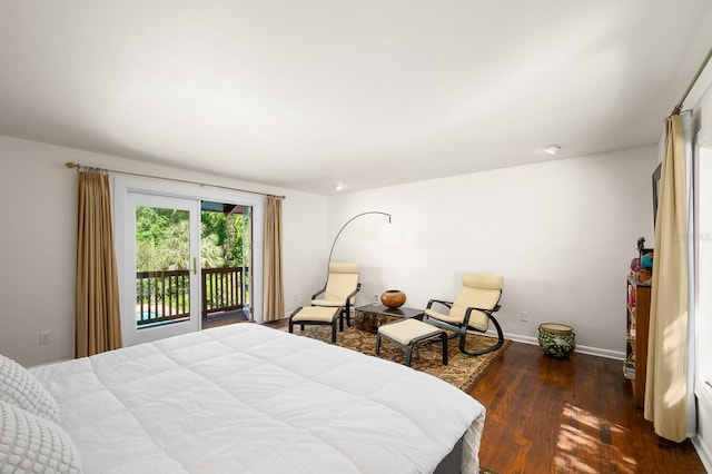 bedroom with baseboards, wood finished floors, and access to exterior