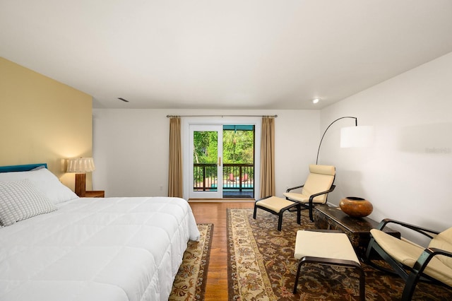 bedroom with access to outside, visible vents, and wood finished floors