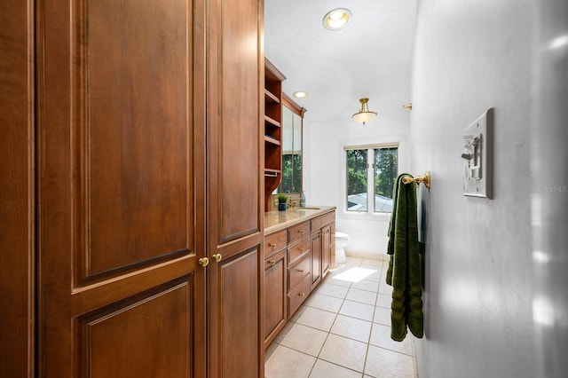 corridor with light tile patterned floors, recessed lighting, and a sink