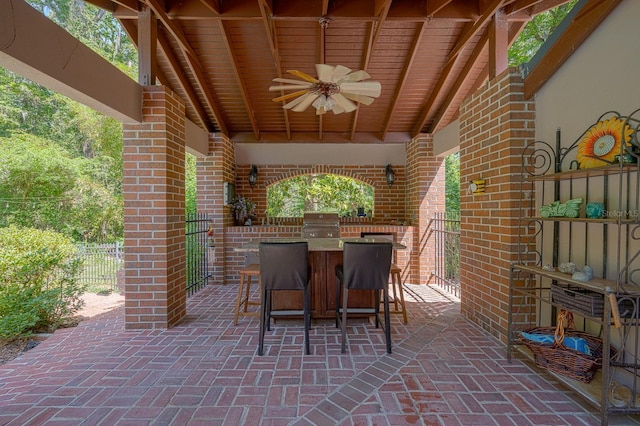 view of patio / terrace with area for grilling, grilling area, a ceiling fan, fence, and outdoor wet bar