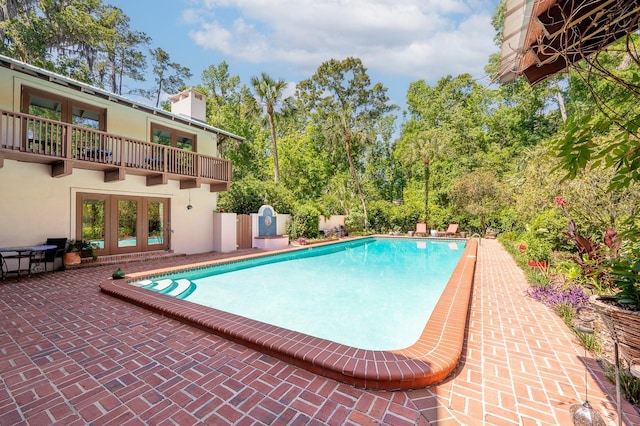 outdoor pool featuring french doors and a patio area