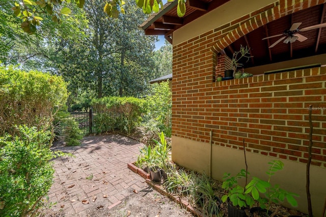 view of home's exterior featuring brick siding, ceiling fan, and a patio area