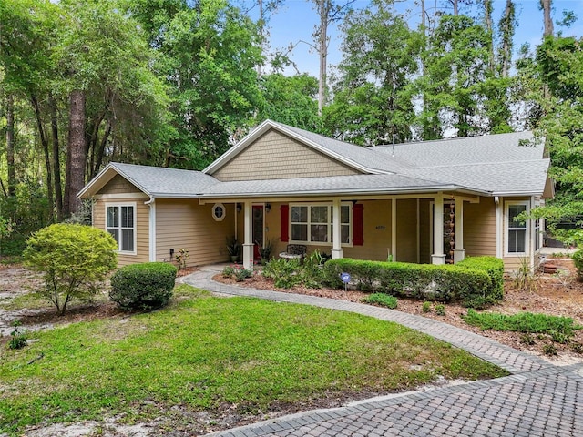 4073 SW 21st Ter, Gainesville, FL 32608 - ranch-style home featuring a shingled roof, a porch, and a front lawn