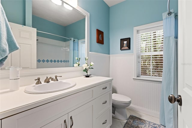 4073 SW 21st Ter, Gainesville, FL 32608 - full bath with tile patterned flooring, vanity, toilet, a shower with shower curtain, and a wainscoted wall