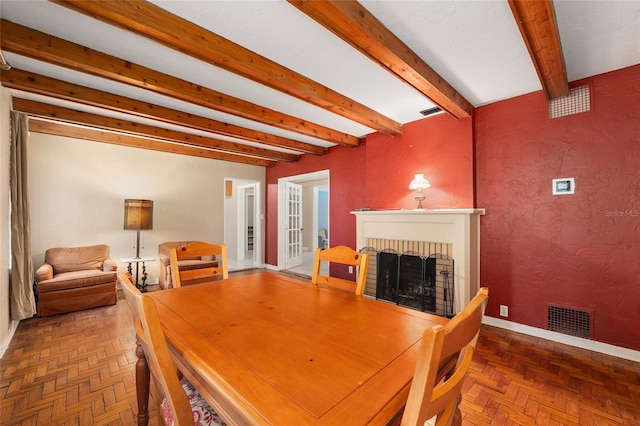 dining room featuring baseboards, visible vents, beam ceiling, and a fireplace