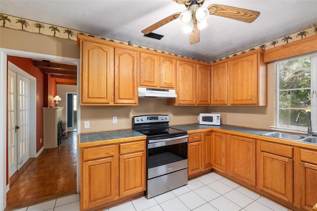 kitchen with stainless steel electric range oven, a sink, a ceiling fan, white microwave, and under cabinet range hood