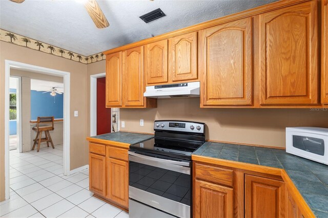 kitchen featuring visible vents, electric range, white microwave, under cabinet range hood, and a ceiling fan