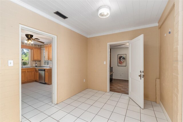 spare room with crown molding, a ceiling fan, visible vents, and light tile patterned floors