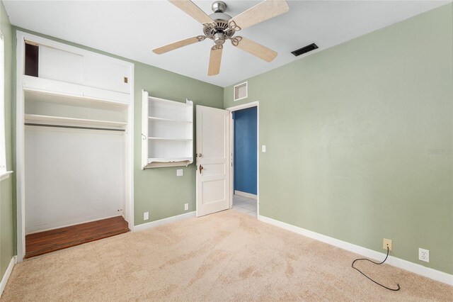 unfurnished bedroom featuring baseboards, visible vents, carpet, and a closet