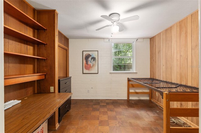 unfurnished office featuring wood walls and ceiling fan