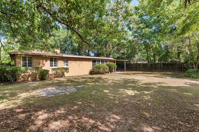 view of yard with fence and an attached carport