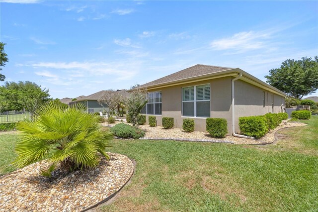 7274 SW 95th Ave, Ocala, FL 34481 - view of property exterior with a yard, fence, and stucco siding