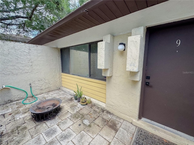 entrance to property featuring a patio and stucco siding