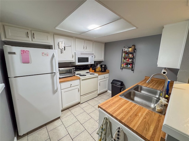 kitchen featuring white cabinets, a sink, white appliances, wooden counters, and light tile patterned floors