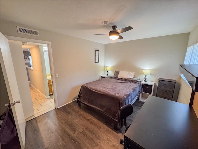 bedroom with baseboards, ceiling fan, wood finished floors, and visible vents