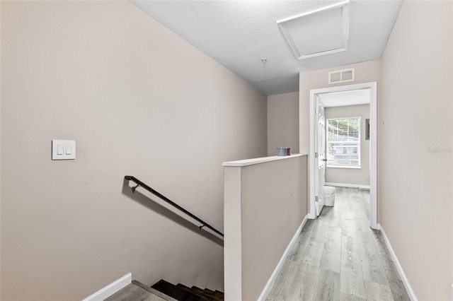 4586 SW 48th Way Unit 106, Gainesville, FL 32608 - corridor with visible vents, light wood finished floors, baseboards, and an upstairs landing