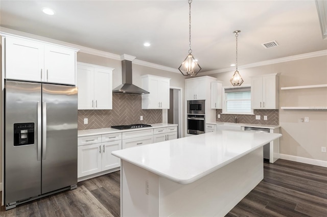 kitchen featuring visible vents, wall chimney exhaust hood, white cabinets, and stainless steel appliances