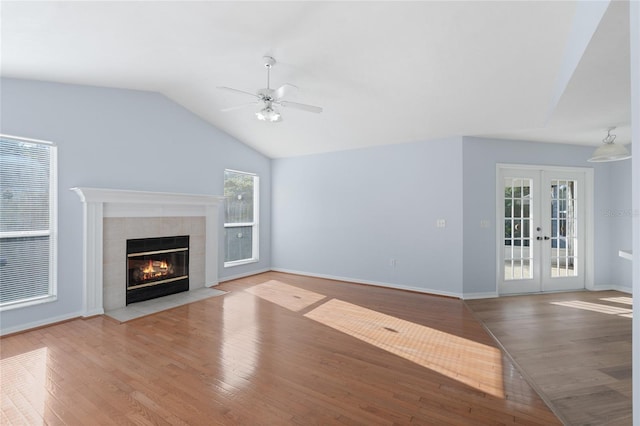 1017 NW 87th Way, Gainesville, FL 32606 - unfurnished living room with ceiling fan, french doors, wood finished floors, lofted ceiling, and a tile fireplace