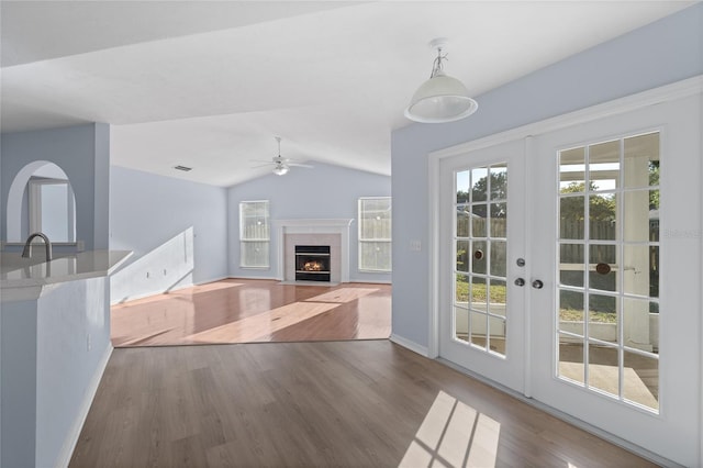 1017 NW 87th Way, Gainesville, FL 32606 - unfurnished living room with ceiling fan, a fireplace with flush hearth, wood finished floors, baseboards, and lofted ceiling