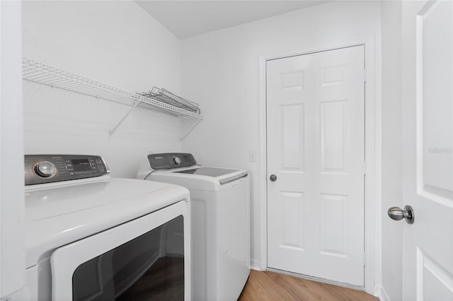 1017 NW 87th Way, Gainesville, FL 32606 - laundry area with laundry area, light wood-type flooring, baseboards, and washing machine and clothes dryer