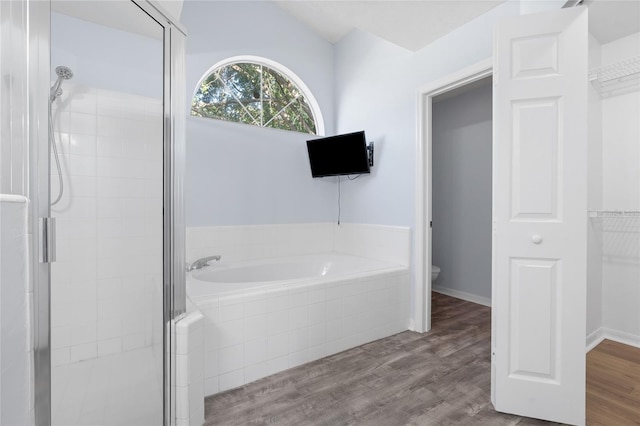 1017 NW 87th Way, Gainesville, FL 32606 - full bathroom with a shower stall, toilet, a bath, and wood finished floors