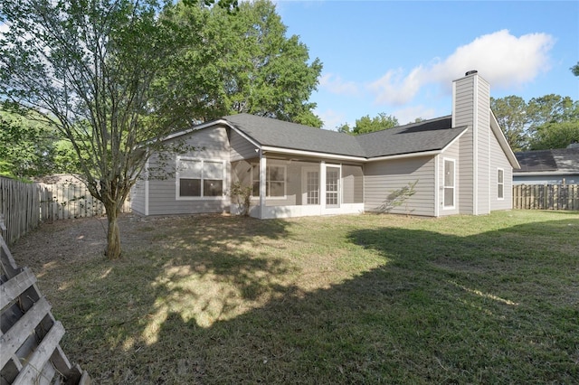 1017 NW 87th Way, Gainesville, FL 32606 - rear view of house with a shingled roof, a sunroom, a fenced backyard, a chimney, and a lawn