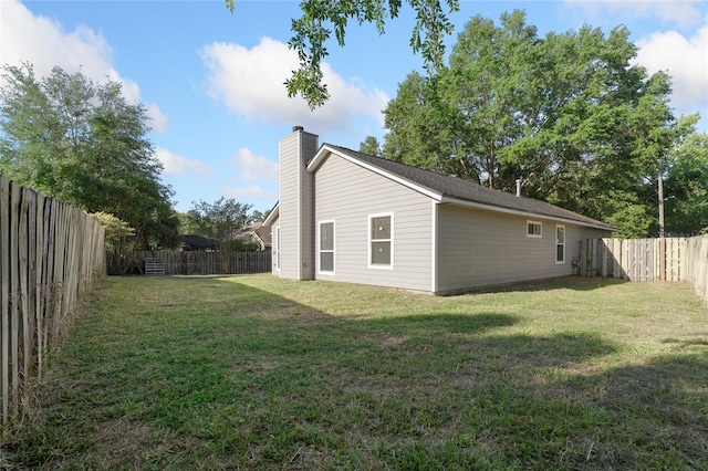 1017 NW 87th Way, Gainesville, FL 32606 - view of side of property with a fenced backyard, a chimney, and a yard